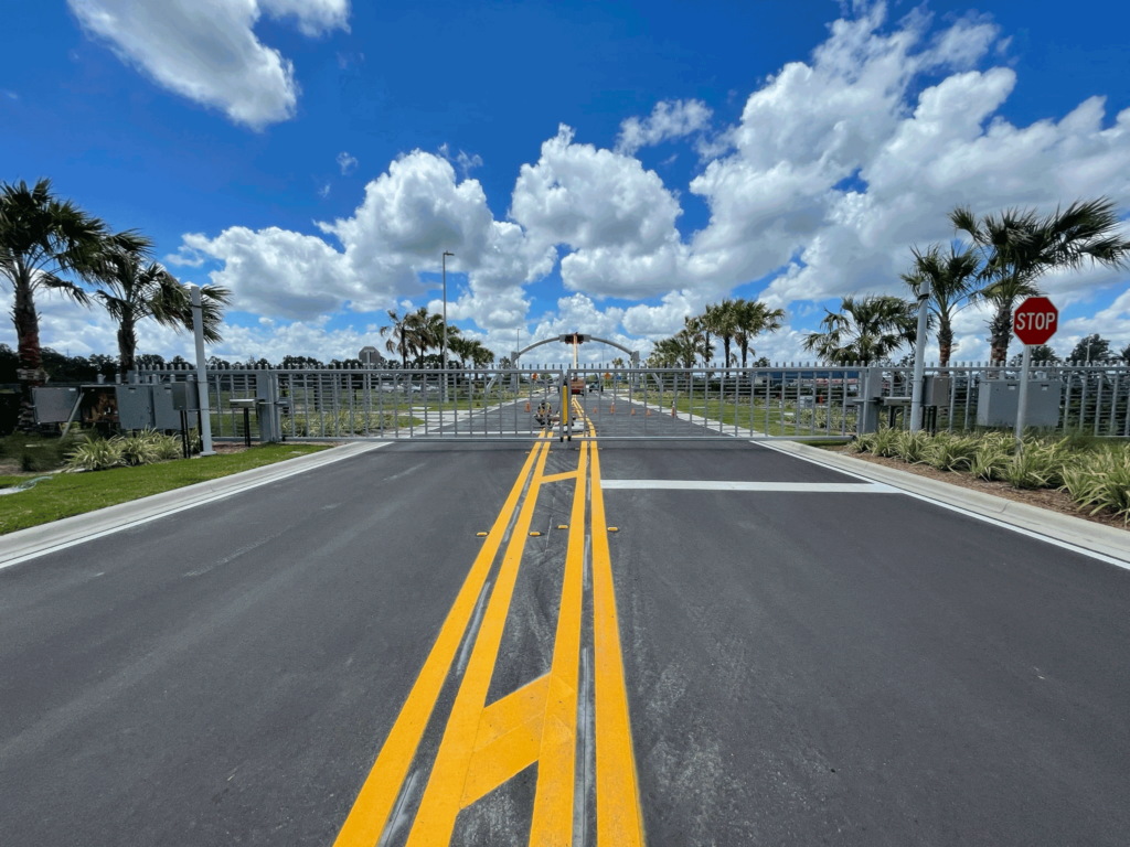 A wide-angle view of the ornamental gates at the SunTrax facility, highlighting their sleek design and secure installation with HydraSwing operators.